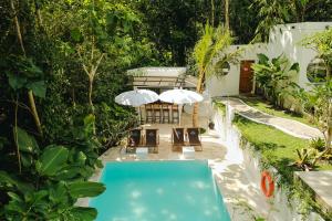 a backyard with a swimming pool and two umbrellas at The Volter Yogyakarta in Ngingas