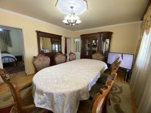 comedor con mesa, sillas y lámpara de araña en VIP Hotel-Villa 3 in the center, en Ereván