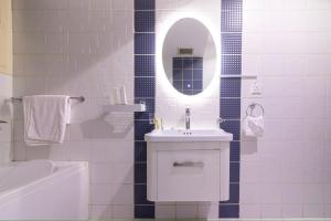 ein weißes Badezimmer mit einem Waschbecken und einem Spiegel in der Unterkunft كمباوند تليد - حطين - الملقا - بوليفارد in Riad