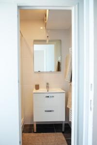 bagno con lavandino e specchio di Le Rozé - Appart'Escale a Saint-Nazaire