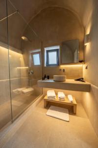 a bathroom with a shower and a sink and a mirror at Alaya Suites in Pyrgos