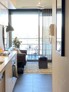 a kitchen and living room with a view of the ocean at Stylish Central Lake View Apartment - free parking in Canberra