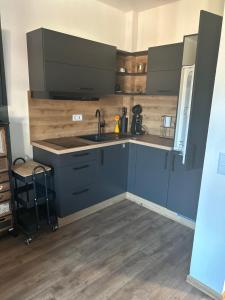 une cuisine avec des armoires bleues et un évier dans l'établissement LITTLE COTTAGE - Kleine Wohlfühloase, à Obernzell