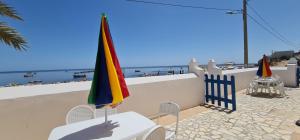 a table and chairs with a flag and the beach at Beit El Ezz - la petite in Ouled Yaneg