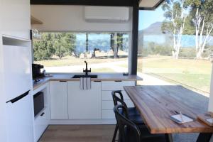 a kitchen with a table and a large window at Avion Retreat in Pumpenbill