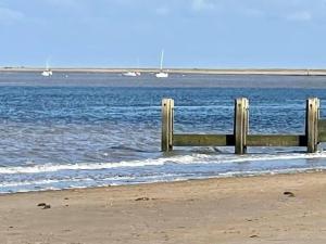 uma cerca de madeira na praia perto da água em Beautiful Seafront Studio Apartment em Cleethorpes