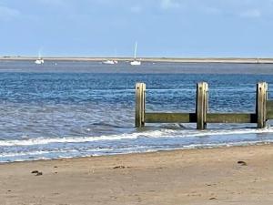 a wooden fence on the beach near the water at Beautiful Seafront Studio Apartment in Cleethorpes