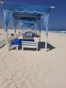 a gazebo on the beach in the sand at North coast sedra resort villa قريه سيدرا الساحل الشمالي in Alexandria