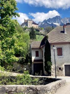 an old house with a mountain in the background at Cabane pour vos vacances à 190m du lac d’Annecy in Menthon-Saint-Bernard