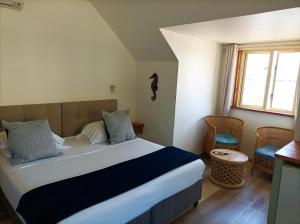 a bedroom with a bed and a window at Hôtel Hamaha Beach in Mamoudzou