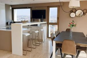 安锡LE SOLAVUE 150 M2 VUE EXCEPTIONNELLE SUR LE LAC的配有桌椅的厨房和餐厅
