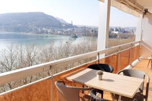 安锡LE SOLAVUE 150 M2 VUE EXCEPTIONNELLE SUR LE LAC的带桌椅的阳台，可欣赏水景