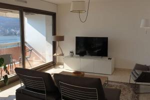 安锡LE SOLAVUE 150 M2 VUE EXCEPTIONNELLE SUR LE LAC的一间带电视和大窗户的客厅