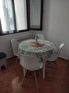 mesa de comedor con sillas blancas y mantel en Timón, cerca de la Playa, en Candás