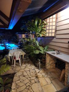 a patio with a sink and a table and chairs at Fare Cocoon in Punaauia