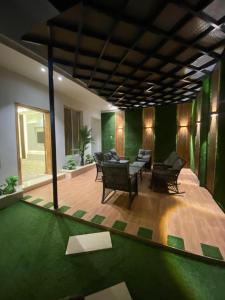 una sala de estar con muebles y una pared verde en شاليهات دار الورد en Taif