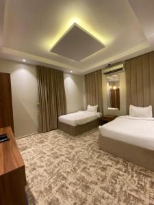 Habitación de hotel con 2 camas y espejo en شاليهات دار الورد en Taif