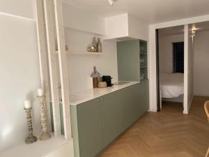 a kitchen with a counter and a room with a bed at Klein geluk te Nieuwpoort. in Nieuwpoort
