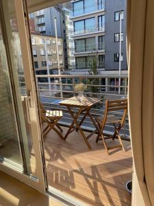 a table and chair on a balcony with a view of a building at Klein geluk te Nieuwpoort. in Nieuwpoort