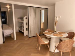 een kamer met een tafel en stoelen en een slaapkamer bij Klein geluk te Nieuwpoort. in Nieuwpoort