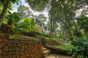 una casa en la selva con una pared de piedra en Ende Wayanad Resort, en Koroth