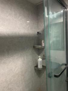 a bathroom with a glass shower with a sink at Sleep Cubee Hostel in Hong Kong