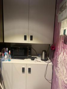 a kitchen with a microwave on top of a counter at Sleep Cubee Hostel in Hong Kong