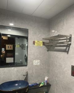 a bathroom with a blue sink and a mirror at Sleep Cubee Hostel in Hong Kong