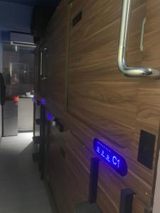 a blue sign on a wooden door in a kitchen at Sleep Cubee Hostel in Hong Kong