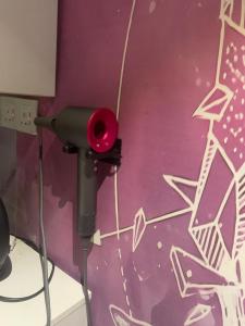 a camera in a room with a purple wall at Sleep Cubee Hostel in Hong Kong