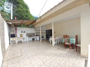 an outdoor patio with a table and chairs at Casa Ubatuba Com Piscina in Ubatuba