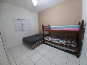 a small room with two bunk beds and a bench at Casa Ubatuba Com Piscina in Ubatuba +31 photos