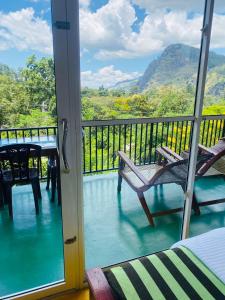 a room with a balcony with a view of the mountains at Little paradise Homestay in Ella