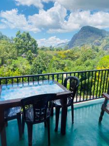 a table and chairs on a balcony with a view at Little paradise Homestay in Ella