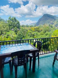 d'une table et de chaises sur un balcon avec vue. dans l'établissement Little paradise Homestay, à Ella