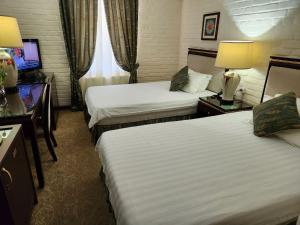 a hotel room with two beds and a television at HL 309 Hotel in Tashkent