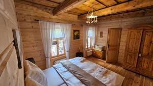 ein Schlafzimmer mit einem Bett in einem Holzzimmer in der Unterkunft Drevenica Borovianka in Veľké Borové