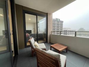 - un balcon avec un canapé et une table dans un bâtiment dans l'établissement Brand new 1BR apartment Dickson, à Canberra