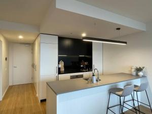 una cocina con barra y dos taburetes. en Brand new 1BR apartment Dickson en Canberra