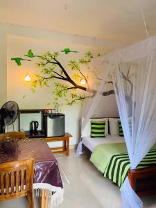 - une chambre avec un lit et un arbre sur le mur dans l'établissement Little paradise Homestay, à Ella