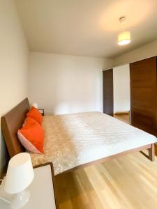 a bedroom with a large bed with orange pillows at européenne union résidence in Brussels