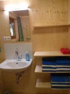 a bathroom with a sink and a mirror and towels at Löchle. Ferienhütte im Bregenzerwald, Andelsbuch in Andelsbuch