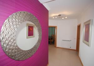 a room with a purple wall with a mirror at Alojamento Turistico in Maceira