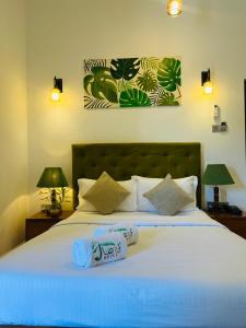 a bedroom with a bed with two towels on it at J Leaf Hotel By Blue Bird in Negombo