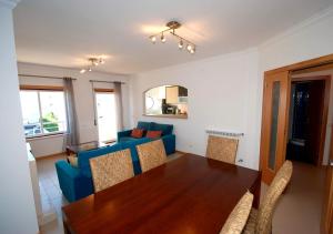 a living room with a table and a blue couch at Alojamento Turistico in Maceira