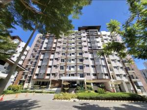 a large apartment building with trees in front of it at Spacious Minimalist Studio at Matina Enclaves in Davao City