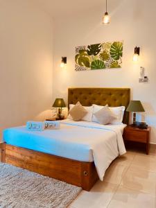 um quarto com uma cama grande e um cobertor azul em J Leaf Hotel By Blue Bird em Negombo