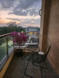 einen Balkon mit 2 Stühlen und einem Topf in der Unterkunft Uber Chic Boutique Stay In City Center in Jaipur