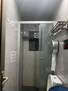 a shower with a glass door in a bathroom at Sleep Cubee Hostel in Hong Kong