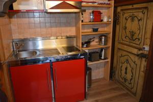 a kitchen with a sink and a red cabinet at Le Vieux Chalet in Gstaad